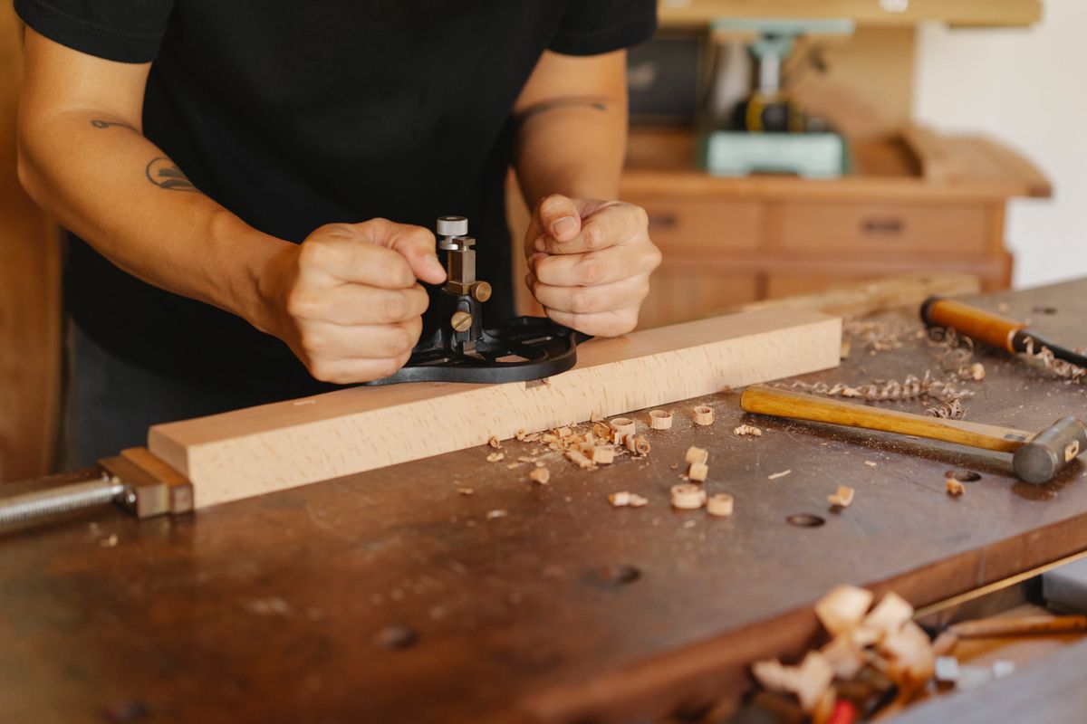 Craftsman working with hand tools at a wooden workbench
